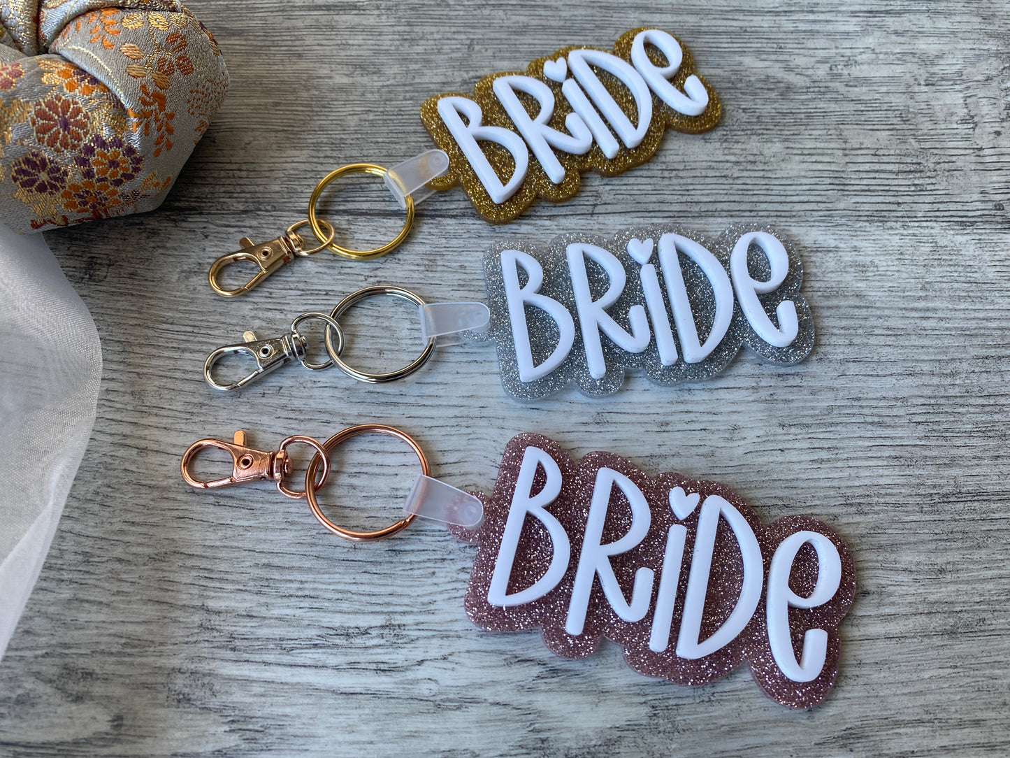 Fun bridal keychain with two layers of acrylic and shiny gold, silver, or pink backing.