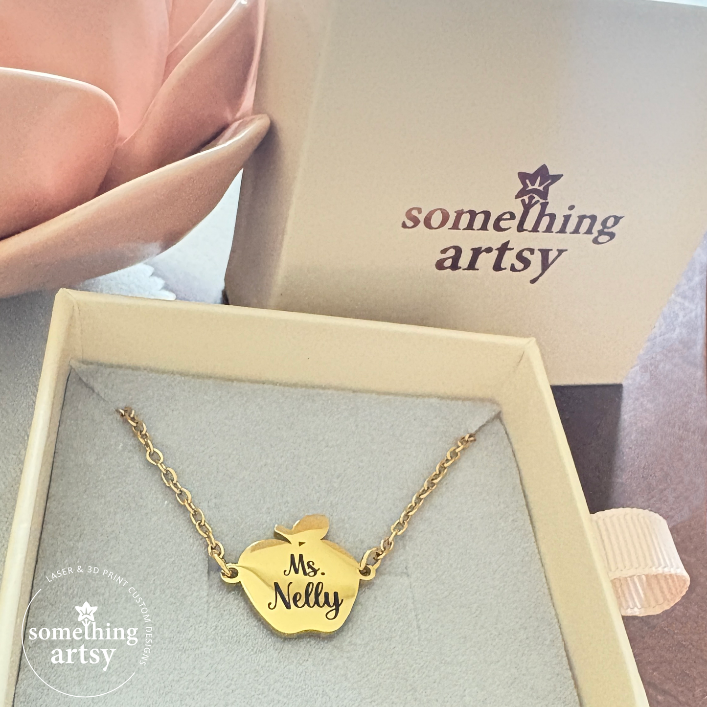 Necklace with an apple charm in gold tone stainless steel, engraved with the words Ms. Nelly