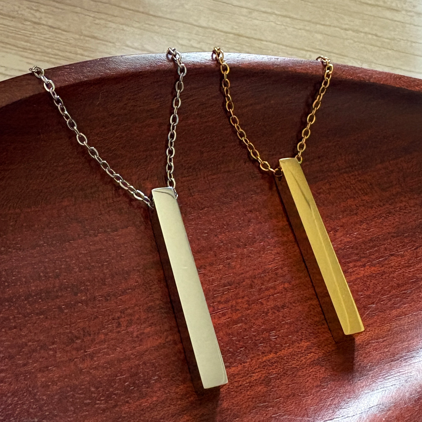 Stainless steel vertical bar necklace in silver and gold finish, with optional engraving on one or multiple sides.