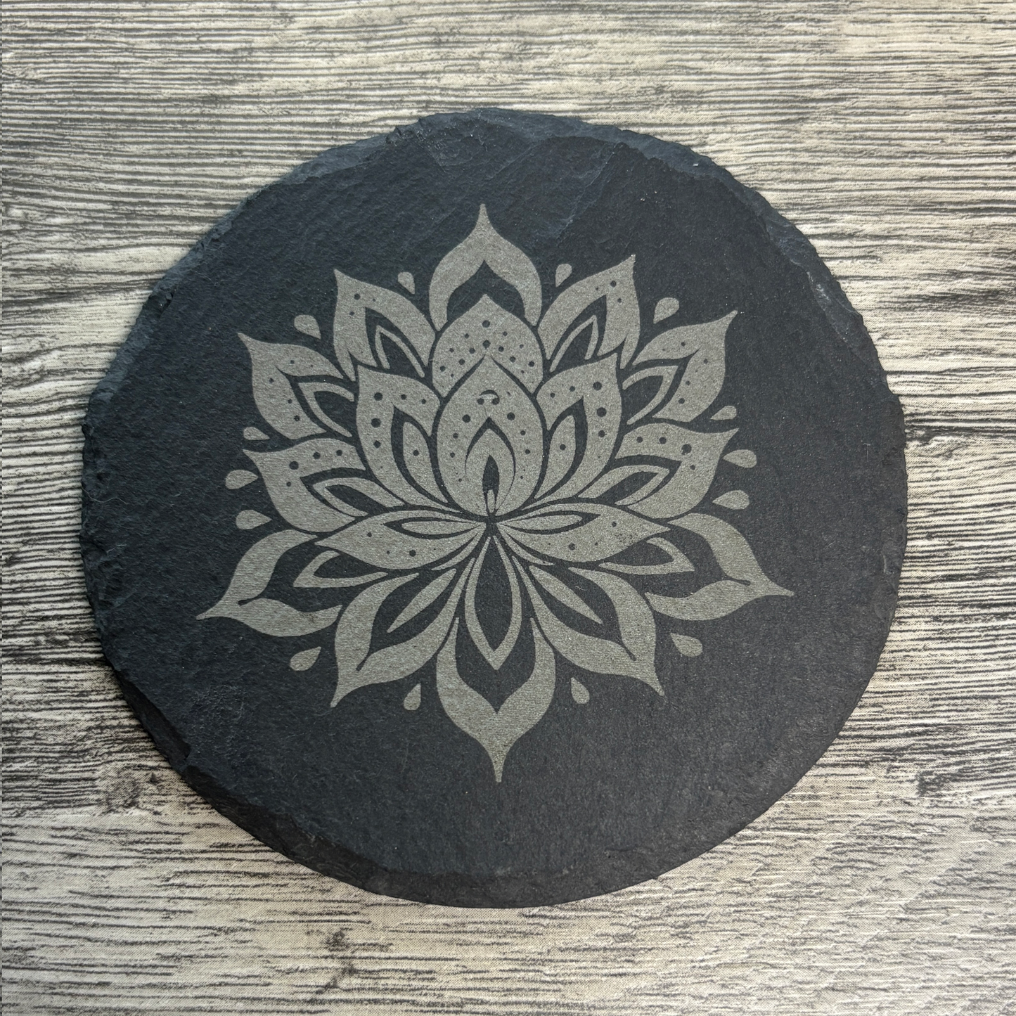 round slate coaster engraved with a flower
