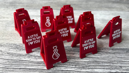 3D-printed mini sign with 'I love you' message & heart gesture with a removable support bar for easy storage