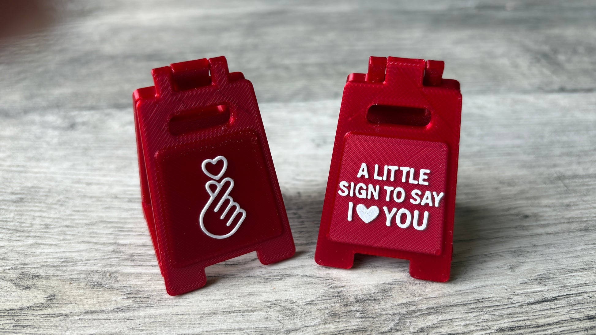 3D-printed mini signs with 'I love you' message & heart gesture with a removable support bar for easy storage