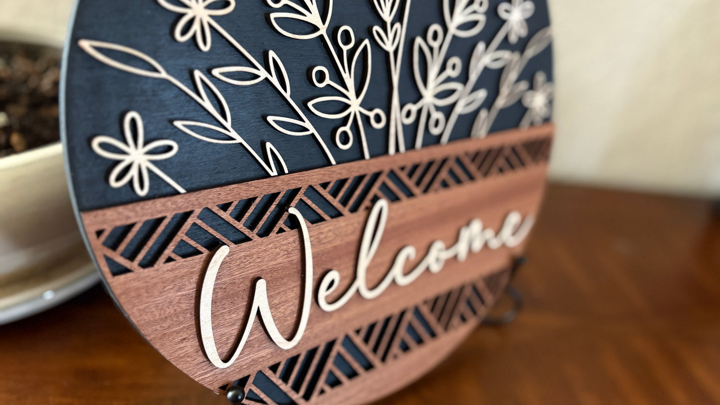 Close up of custom wood welcome sign with elegant floral cutouts.