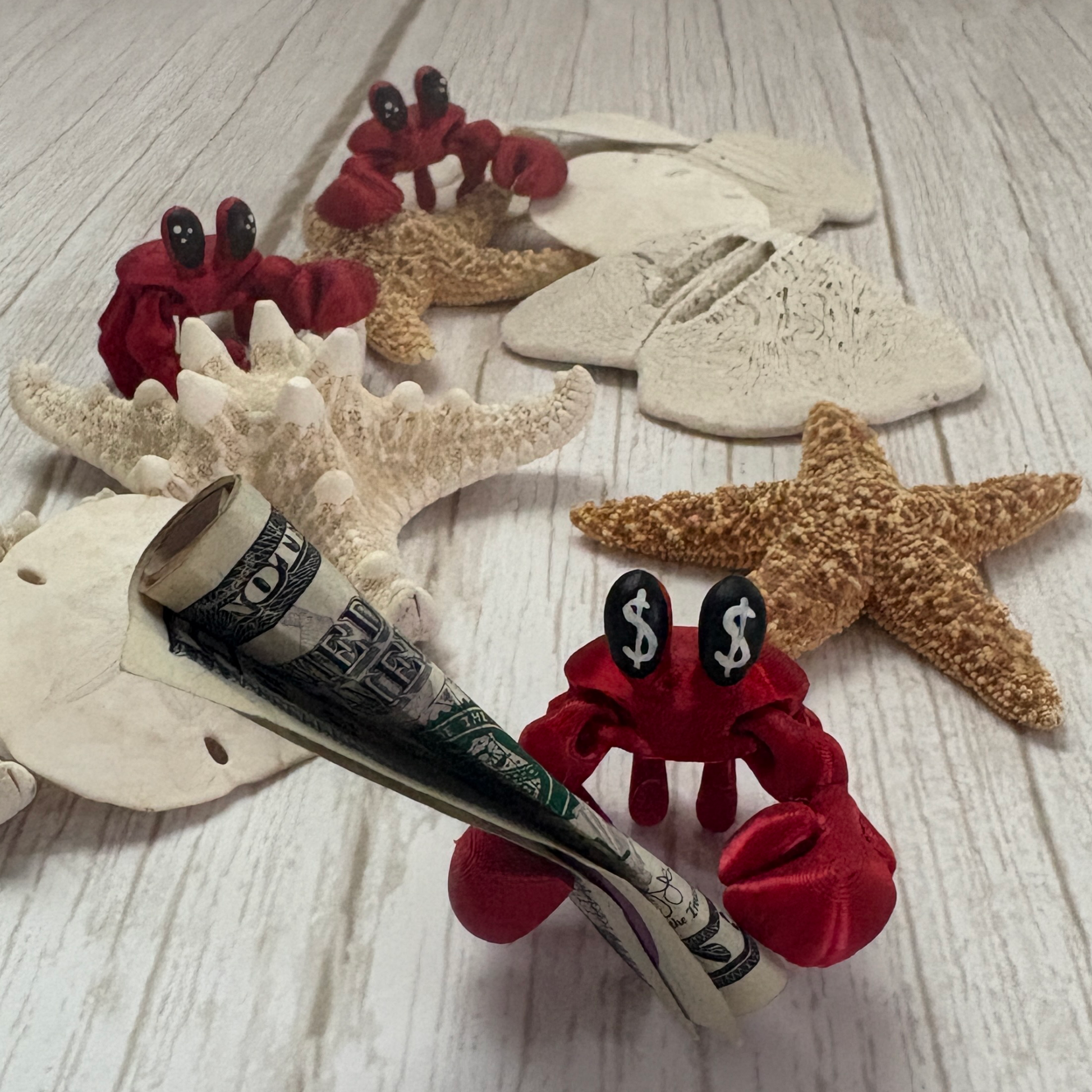 3D printed articulated crab with moveable claws holding a bill, available with money symbol eyes or classic eyes, great as a gift or money holder.