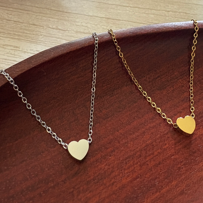 Tiny Heart Charm crafted from mirror-polished stainless steel and available in silver or gold finishes that can be custom engraved