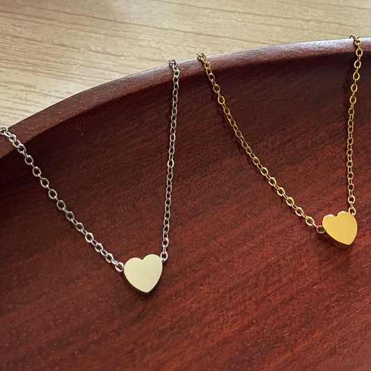 Tiny Heart Charm crafted from mirror-polished stainless steel and available in silver or gold finishes that can be custom engraved