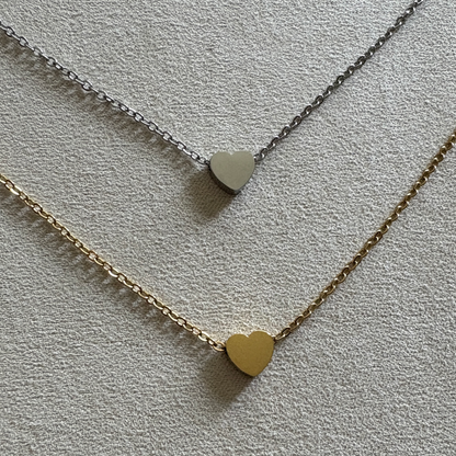 Stainless steel tiny heart charm in silver and gold finish.