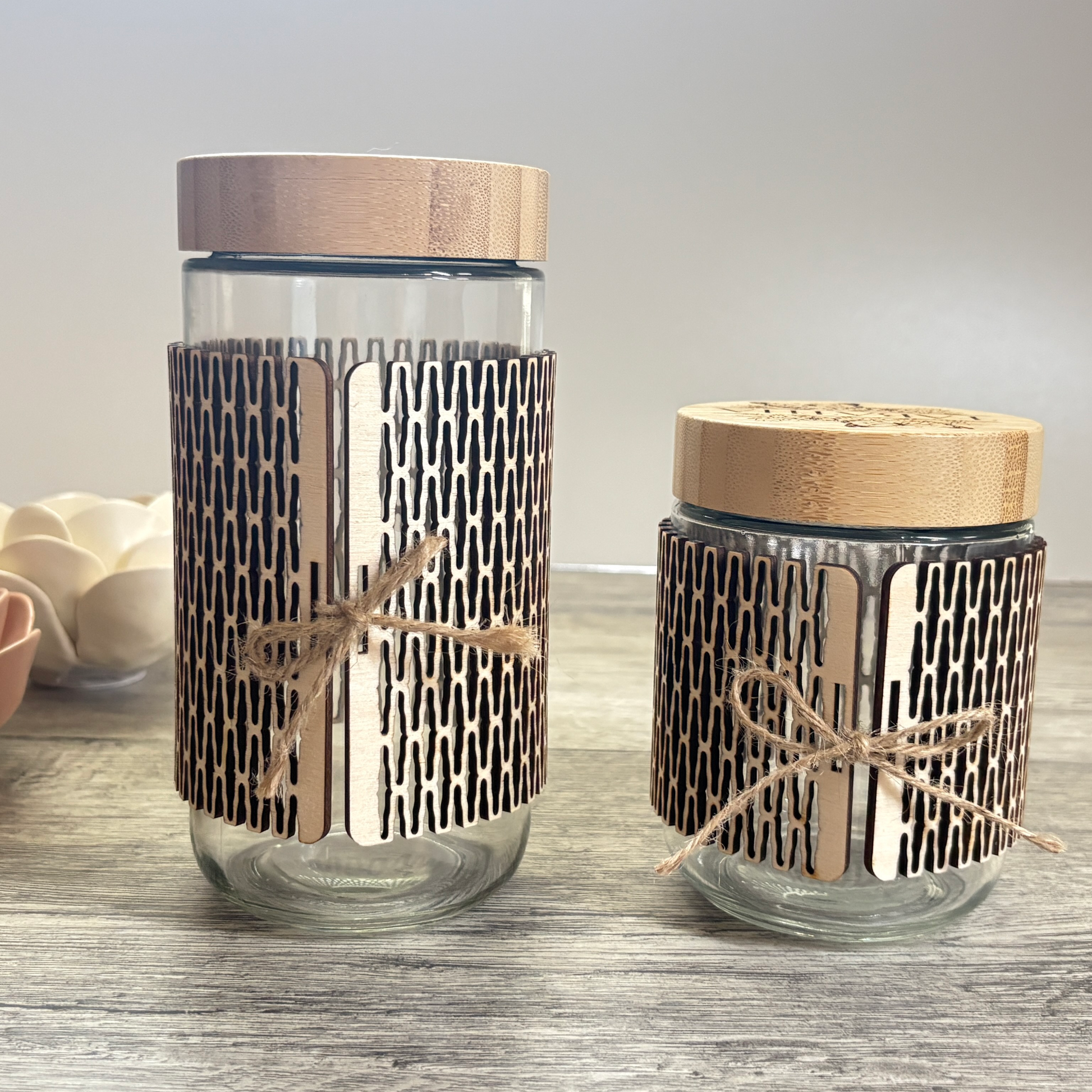 Back view of the 24oz and 16oz glass jars with the wooden sleeve and a small jute ribbon closing the sleeve.