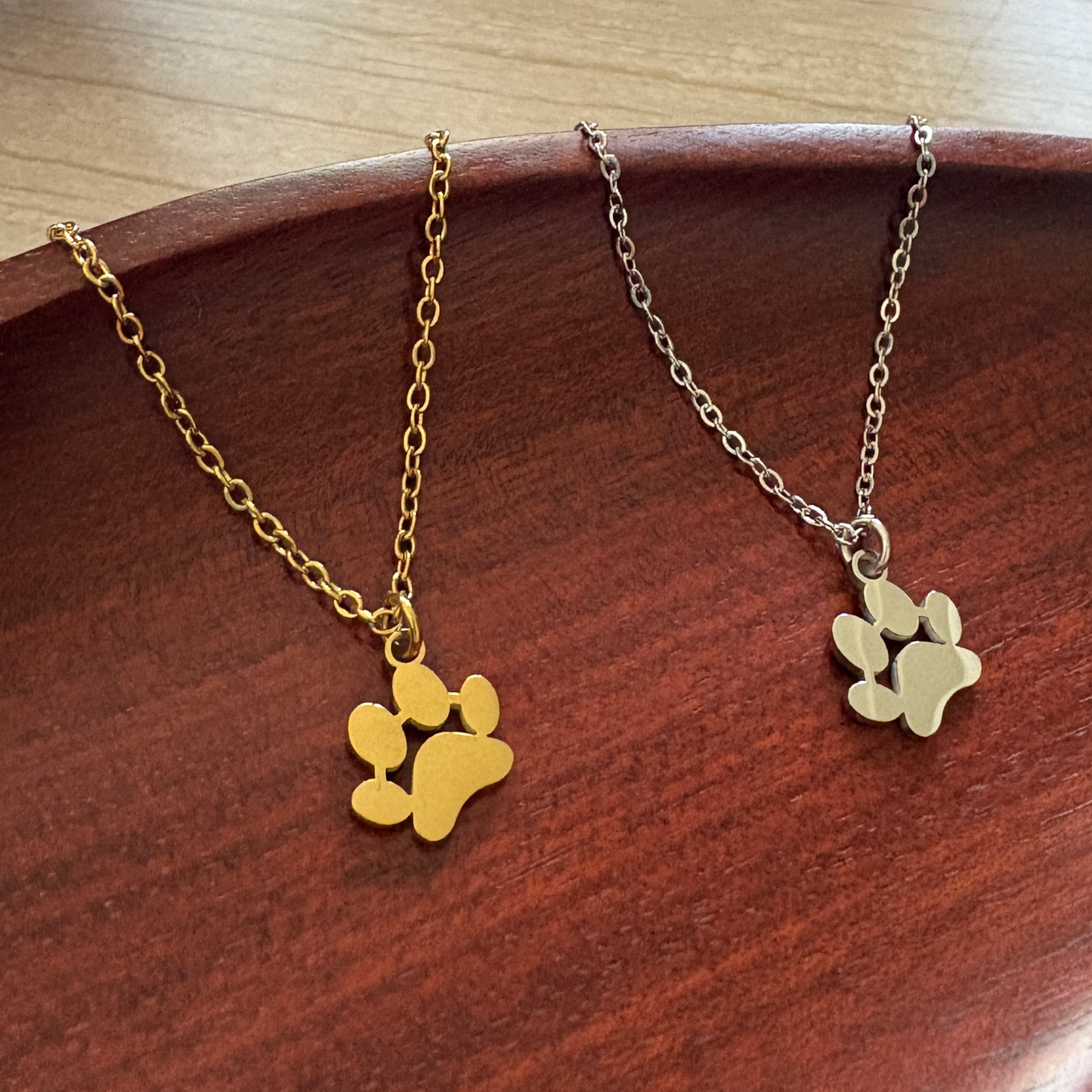 Petite Paw Print charms, available in silver or gold-tone stainless steel that can be customize with a name or initials