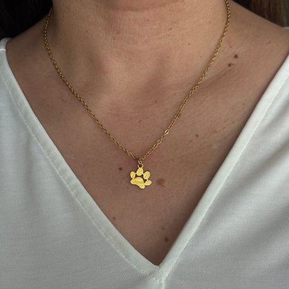 The gold paw necklace in display with someone wearing it