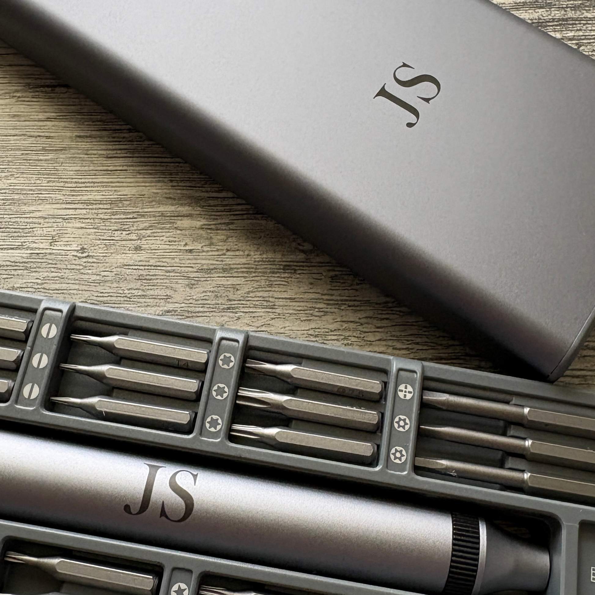 Close up of 52-in-1 Electric Screwdriver Set with custom engraving initials JS on the case and tool.